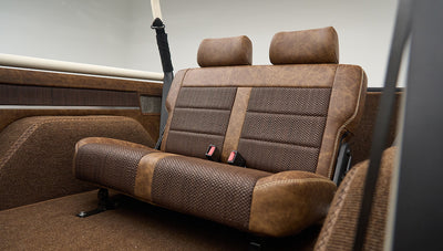 Close-up of rear bench seat with seat belts featuring brown upholstery in Classic Ford Bronco Lime Gold