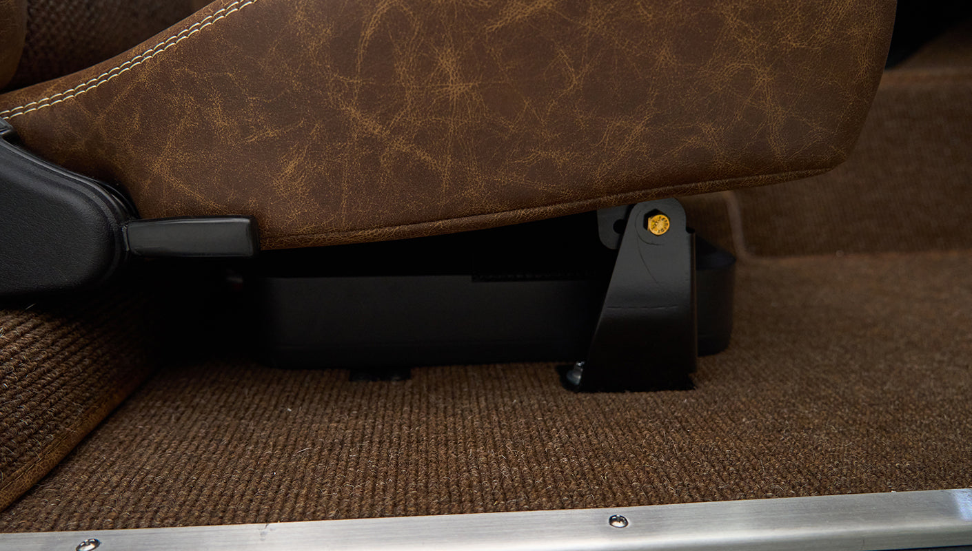Brown leather seat bottom and side bracket with brown carpeted floor in Classic Ford Bronco interior