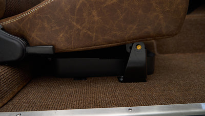 Brown leather seat bottom and side bracket with brown carpeted floor in Classic Ford Bronco interior