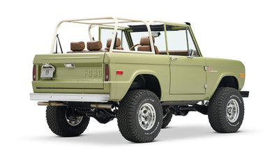 Rear three-quarter side view of lime green Classic Ford Bronco with lifted suspension and tan interior