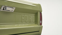 Rear tailgate of Classic Ford Bronco in lime gold color with embossed FORD lettering and taillight