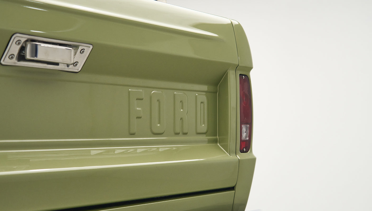 Rear tailgate of Classic Ford Bronco in lime gold color with embossed FORD lettering and taillight