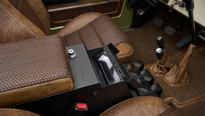 Brown leather armrest and open storage compartment between brown seats in Classic Ford Bronco interior