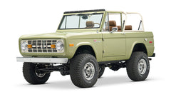 Front three-quarter view of lime green Classic Ford Bronco with lifted tires and open top