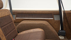Back seats and interior side panel with brown upholstery and beige roll cage in Classic Ford Bronco