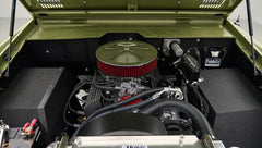 Engine compartment of Classic Ford Bronco in lime gold showing air filter and wiring
