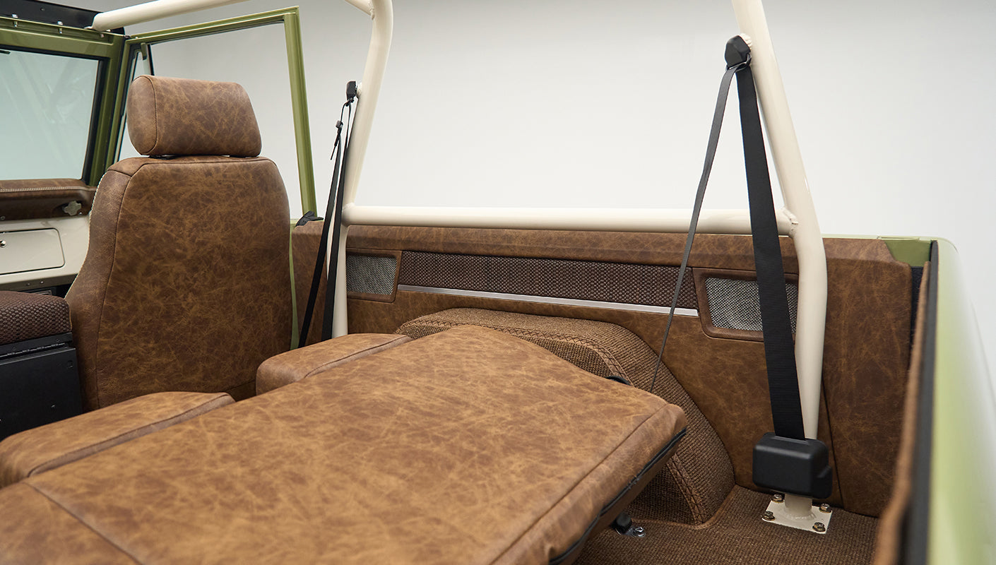 Rear interior of Classic Ford Bronco with folded-down seat and brown upholstery