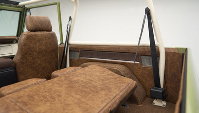 Rear interior of Classic Ford Bronco with folded-down seat and brown upholstery