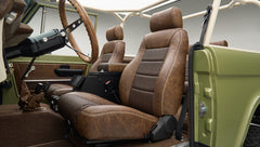 Interior view showing driver and passenger vintage brown leather seats and part of steering wheel