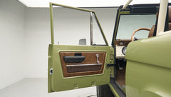 Classic Ford Bronco door panel with brown and black trim and chrome handles
