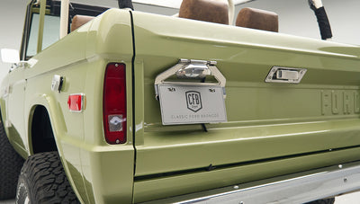 Close-up of rear of lime green Classic Ford Bronco showing tailgate, taillights, and license plate