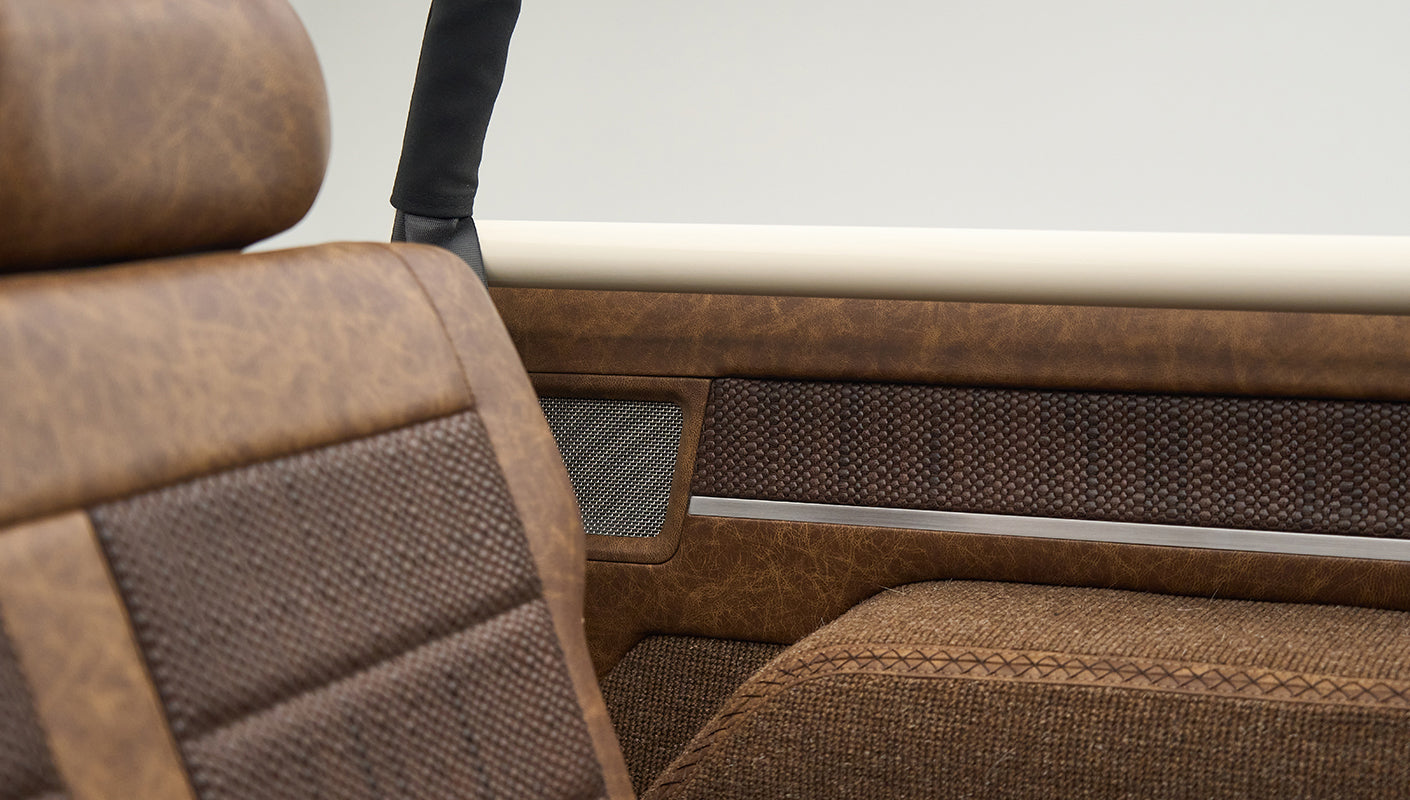 Close-up of brown textured upholstery on the interior side panel and seat of Classic Ford Bronco