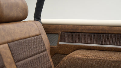 Close-up of brown textured upholstery on the interior side panel and seat of Classic Ford Bronco