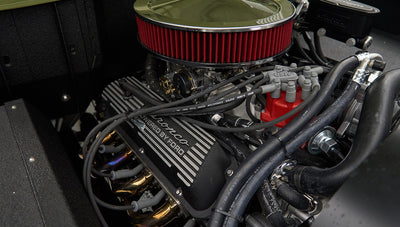 Engine detail with 'Bronco Powered by Ford' on valve cover and red ignition wires