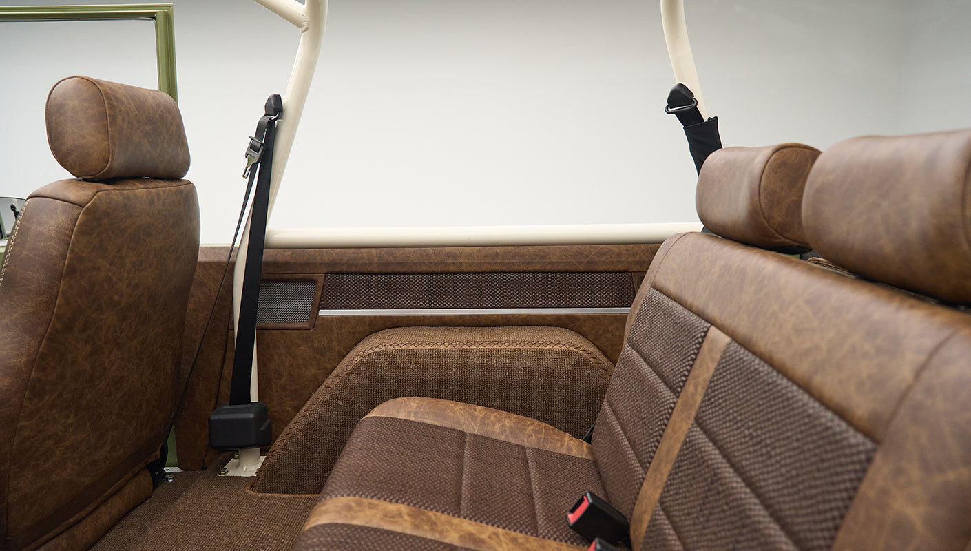 Rear seat side view showing brown upholstery with headrest and seat belt in Classic Ford Bronco Lime Gold