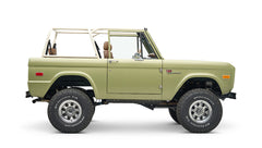 Side profile of lime green Classic Ford Bronco with roll cage and off-road tires