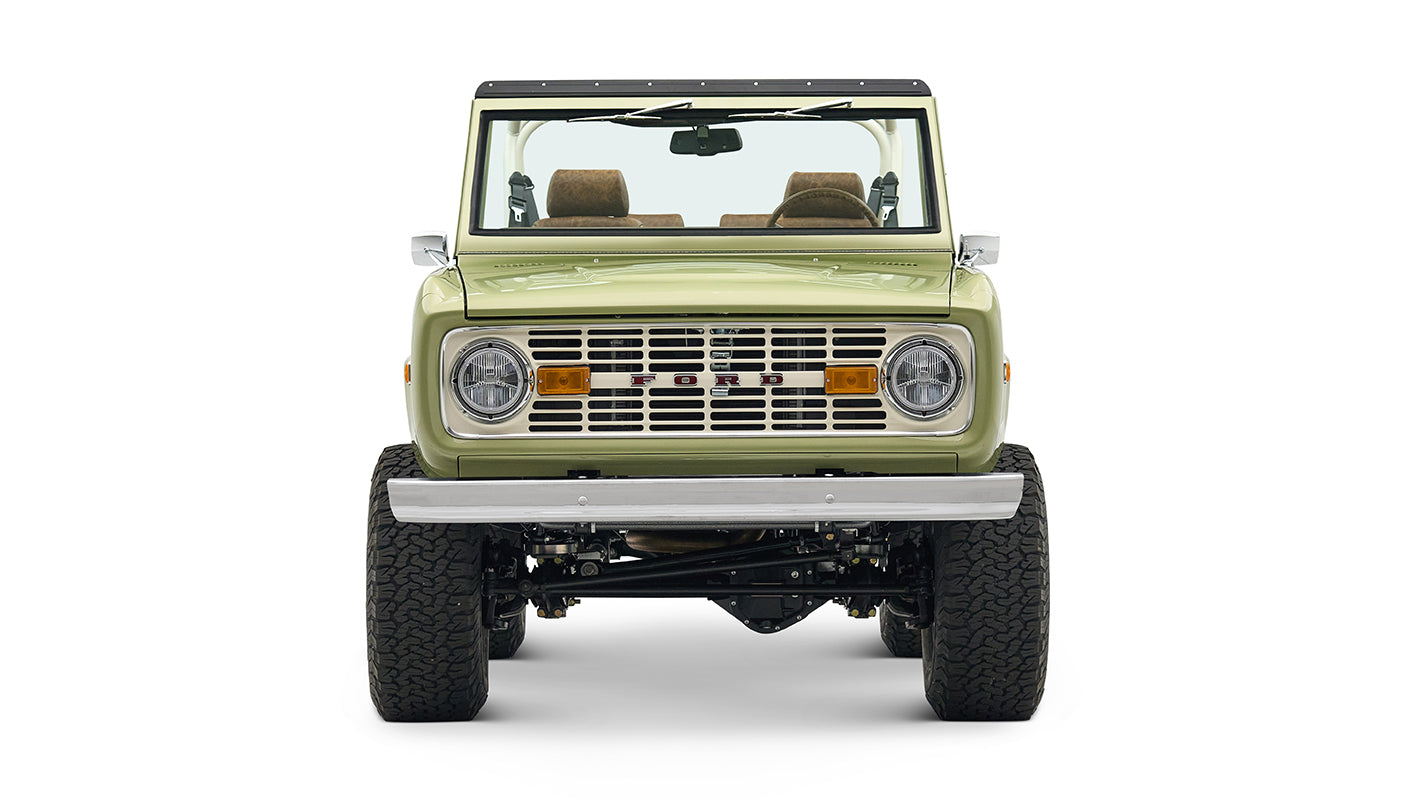 Front view of lime green Classic Ford Bronco showcasing grille, headlights, and bumper