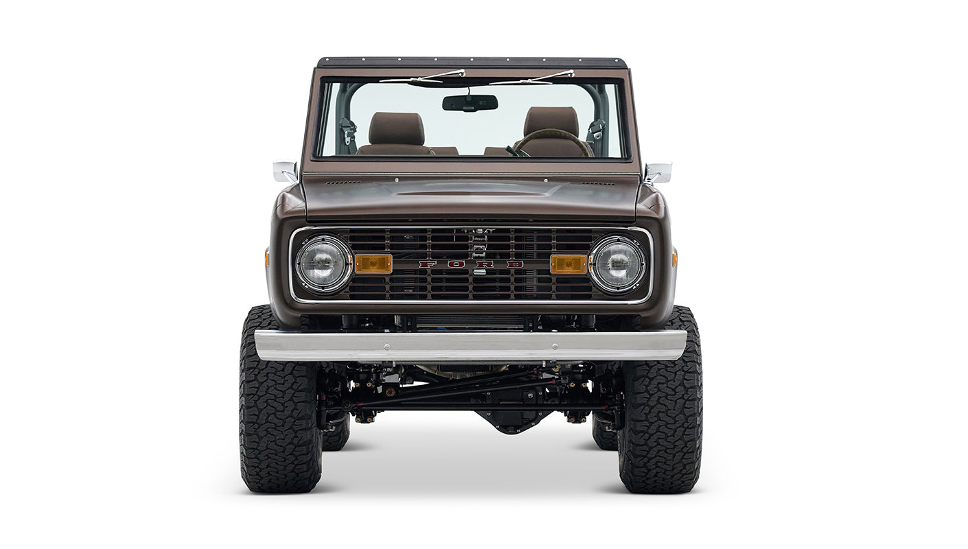 Front view of matte brown Classic Ford Bronco with round headlights and steel bumper