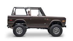 Matte brown Classic Ford Bronco side view with open roof showing driver and rear seats