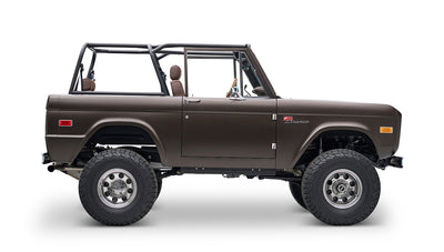 Matte brown Classic Ford Bronco side view with open roof showing driver and rear seats