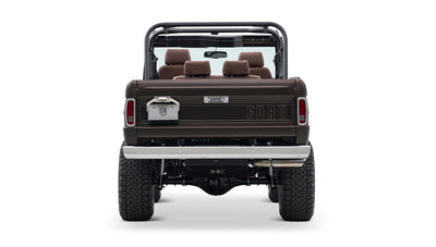 Rear view of matte brown Classic Ford Bronco with chrome bumper and visible suspension