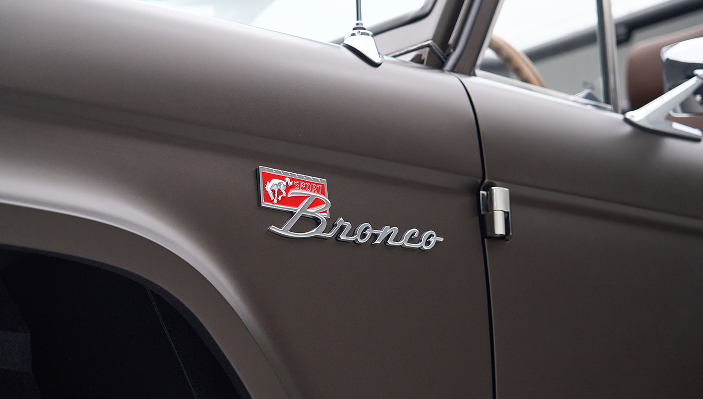 Close-up of 'Sport Bronco' badge on matte brown Classic Ford Bronco driver door
