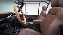 View of brown leather seats and wooden steering wheel inside classic Ford Bronco interior