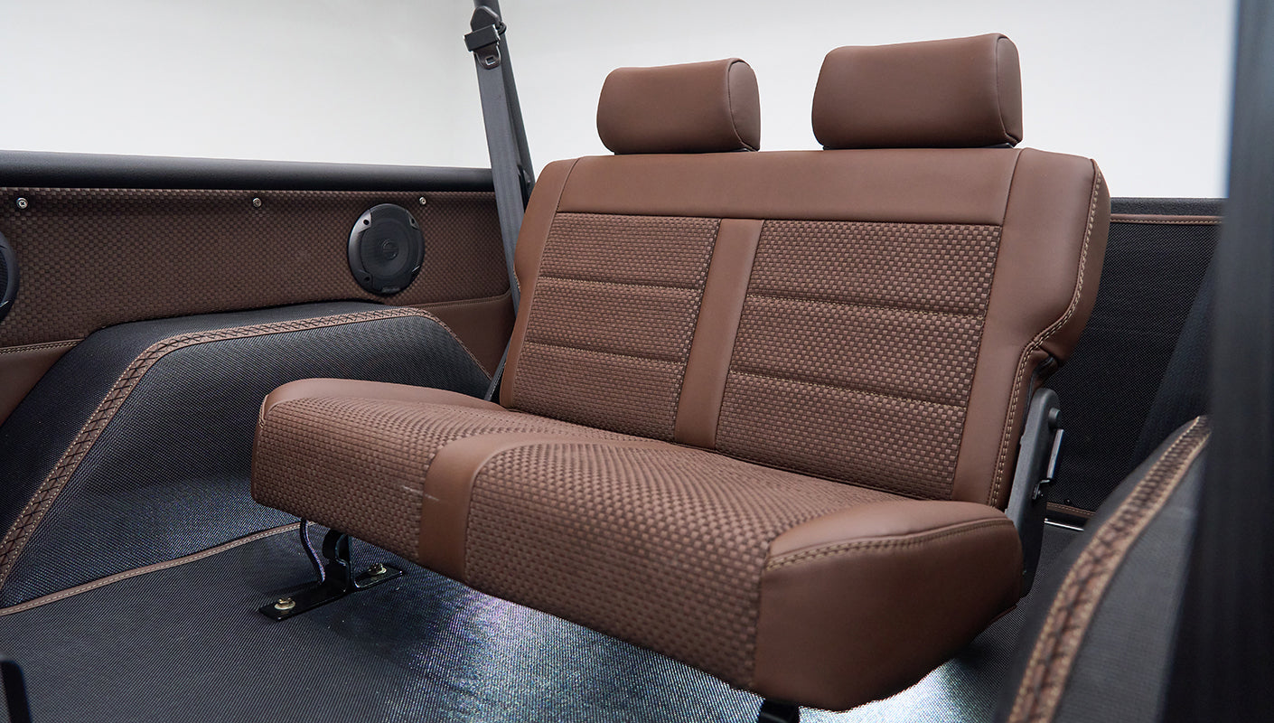 Rear bench seat with brown leather and fabric upholstery in Classic Ford Bronco interior