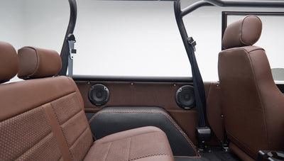 Back seats and side panels with speakers and seat belts inside Classic Ford Bronco in matte brown color