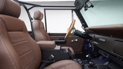 Driver side interior of Classic Ford Bronco showing brown seats and dashboard
