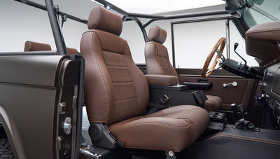 Interior view of front seats and steering wheel in Classic Ford Bronco with matte brown upholstery