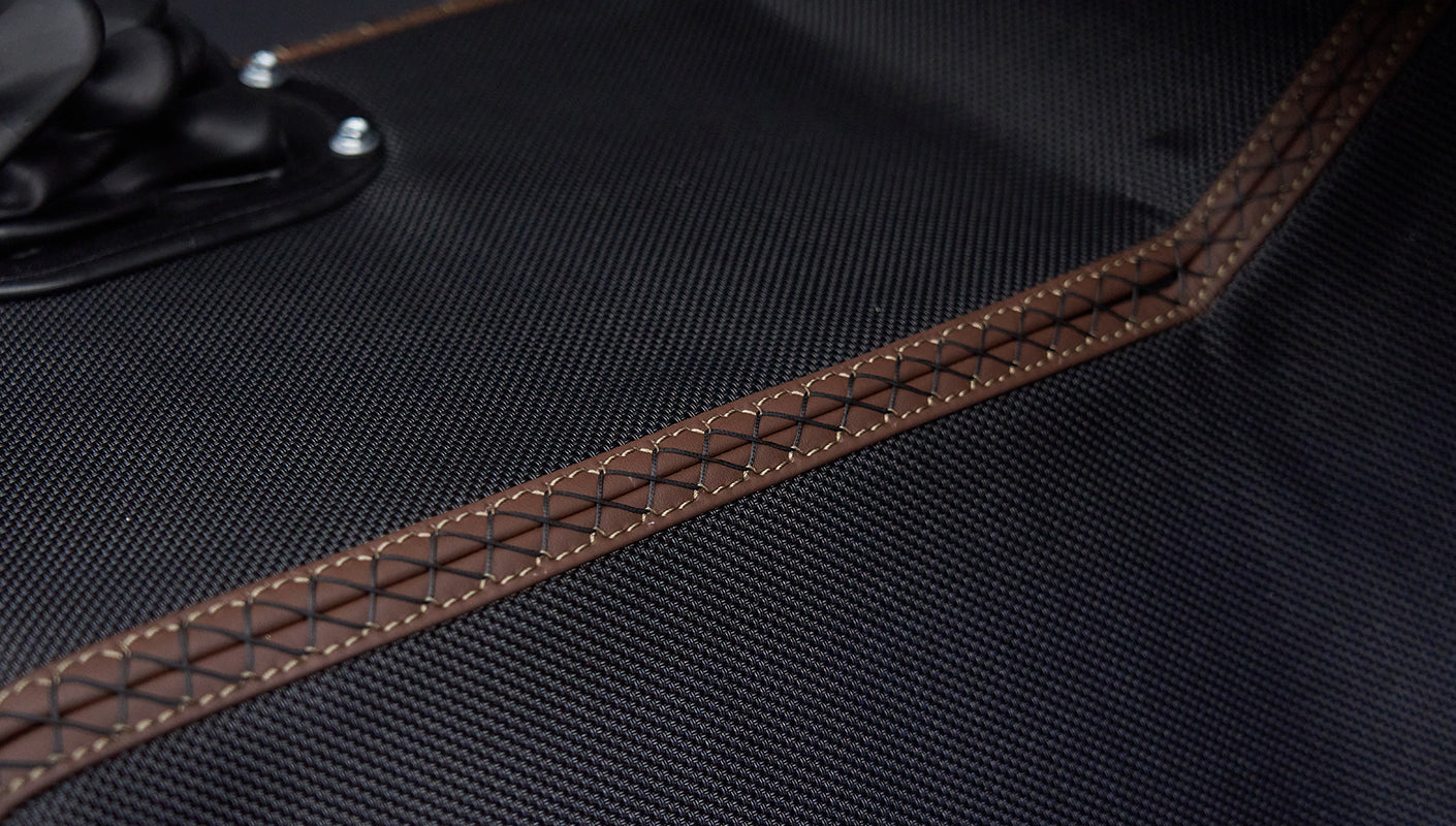 Close-up of black textured floor mat with brown stitching inside Classic Ford Bronco