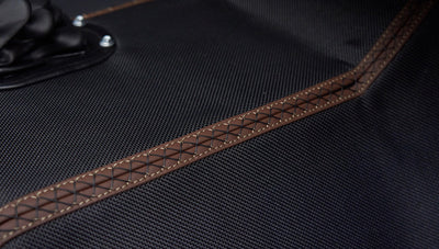Close-up of black textured floor mat with brown stitching inside Classic Ford Bronco