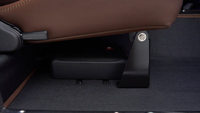 Speaker installed under front seat bracket on textured floor mat inside Classic Ford Bronco
