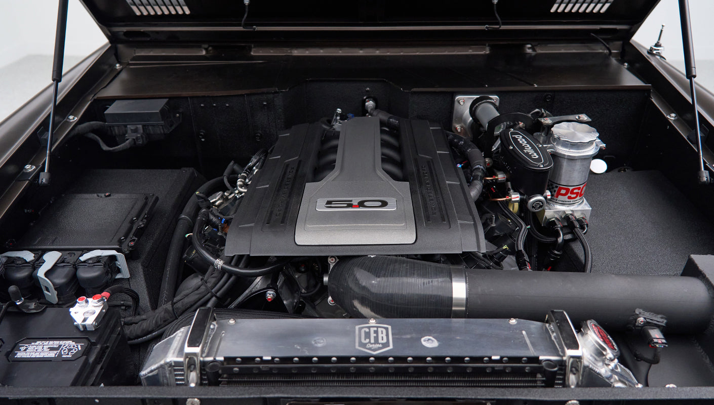 Close-up of Classic Ford Bronco engine bay with 5.0 emblem on engine cover