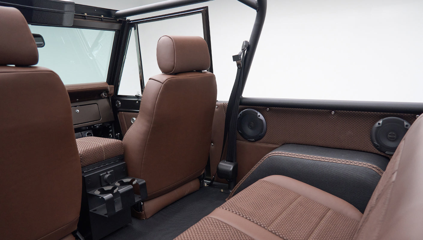 Interior rear view of Classic Ford Bronco with brown leather seats and black roll bar
