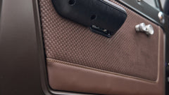 Close-up of brown textured and leather door panel inside Classic Ford Bronco