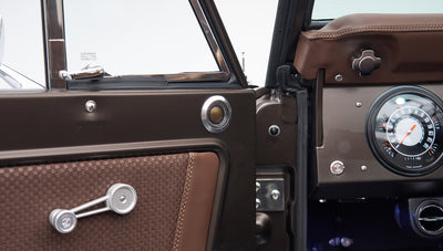 Close-up of Classic Ford Bronco's brown door panel with speaker and window crank