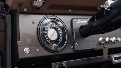 Close-up of speedometer and Bronco emblem on dashboard inside Classic Ford Bronco
