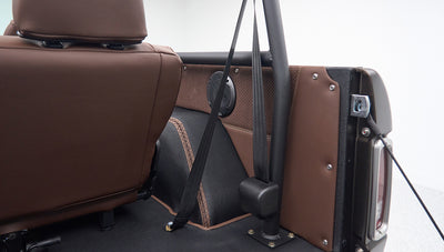 Brown leather interior and seat belt detail inside Classic Ford Bronco near wheel well