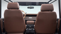 Front seats and dashboard view from rear of Classic Ford Bronco with brown leather seats