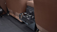 Fold-out black cupholder attached behind front seats inside Classic Ford Bronco