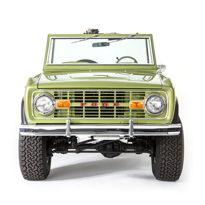 Front view of light green Classic Ford Bronco with large tires and chrome bumper