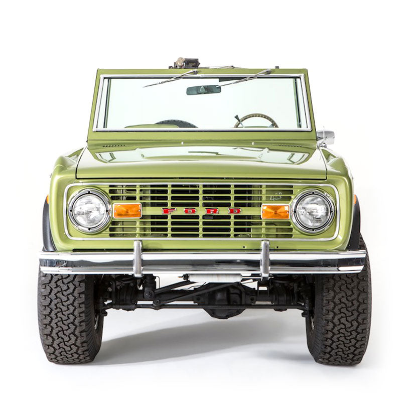 Front view of light green Classic Ford Bronco with large tires and chrome bumper