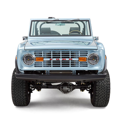 Front view of light blue Classic Ford Bronco with large off-road tires and windshield