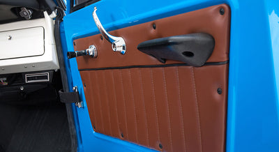 Close-up of brown leather and blue door panel interior of vehicle