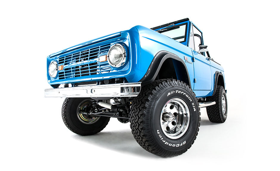 Bright blue Classic Ford Bronco angled front view isolated on white background