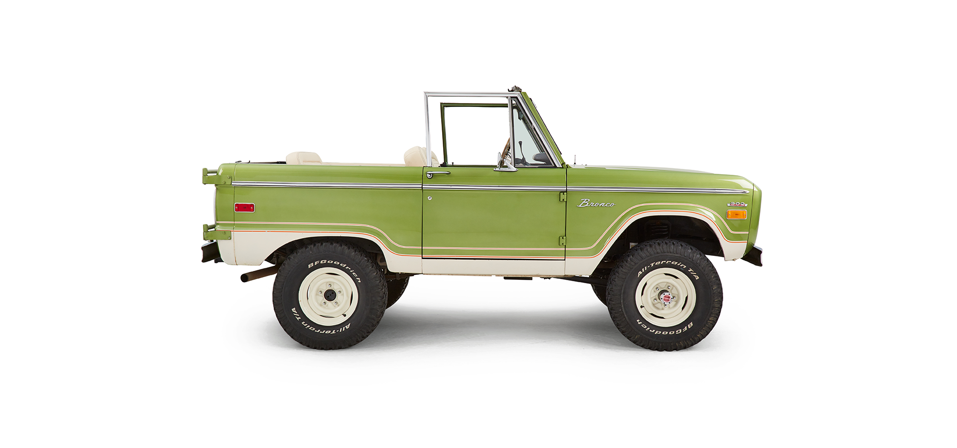 Side view of green Classic Ford Bronco with beige seats and no roof