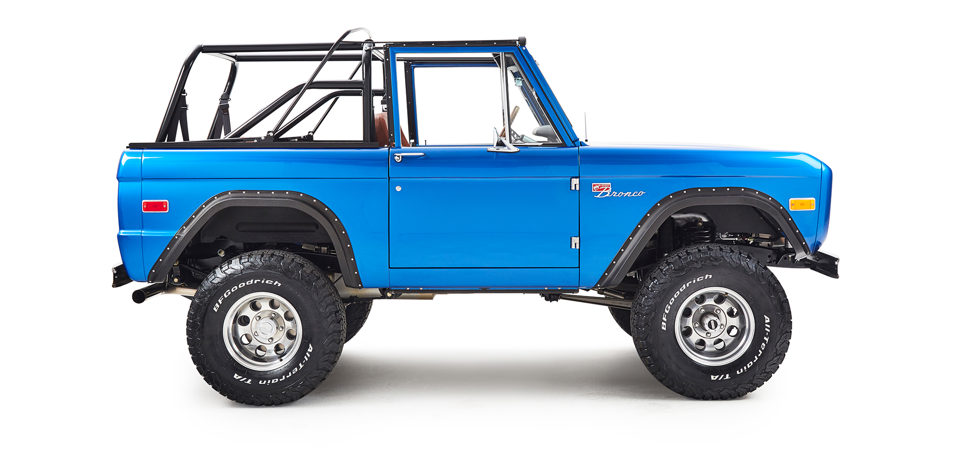 Side view of a blue Classic Ford Bronco showing passenger side and open roll cage