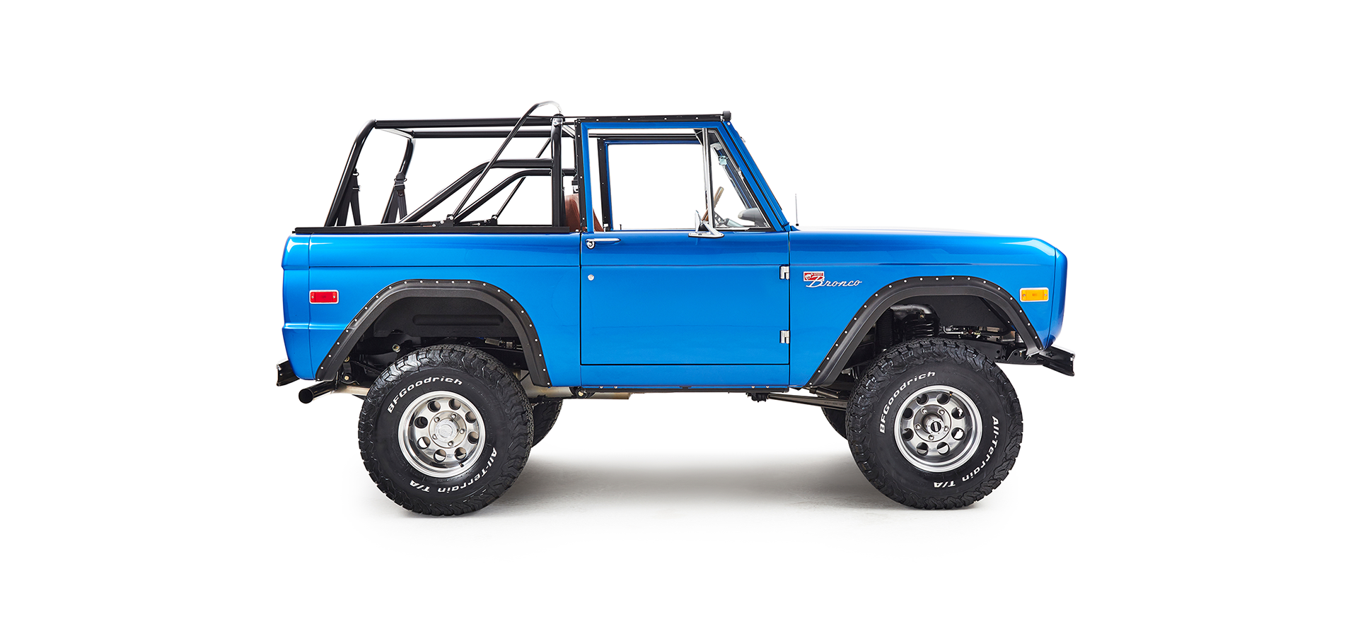 Classic Ford Bronco in blue shown from passenger side with roll cage and rugged tires